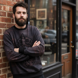 Man with a beard leaning against a brick wall in an urban setting