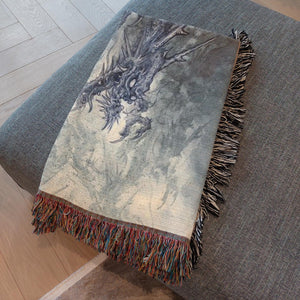 Jojo Ackermann's Dragon Blanket displayed on a bed – 60x80" woven cotton throw.