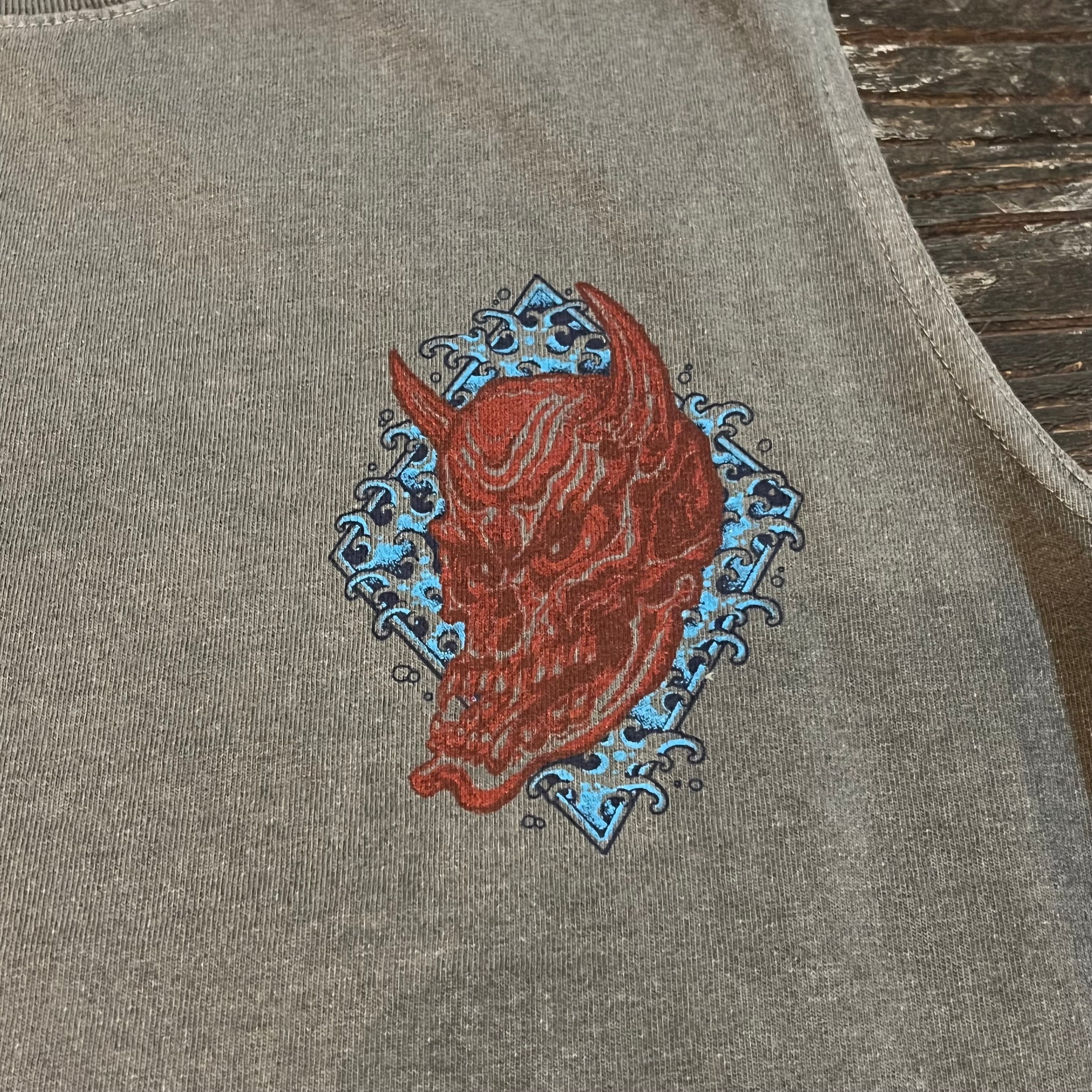 Embroidered design on a gray fabric with a red and blue pattern