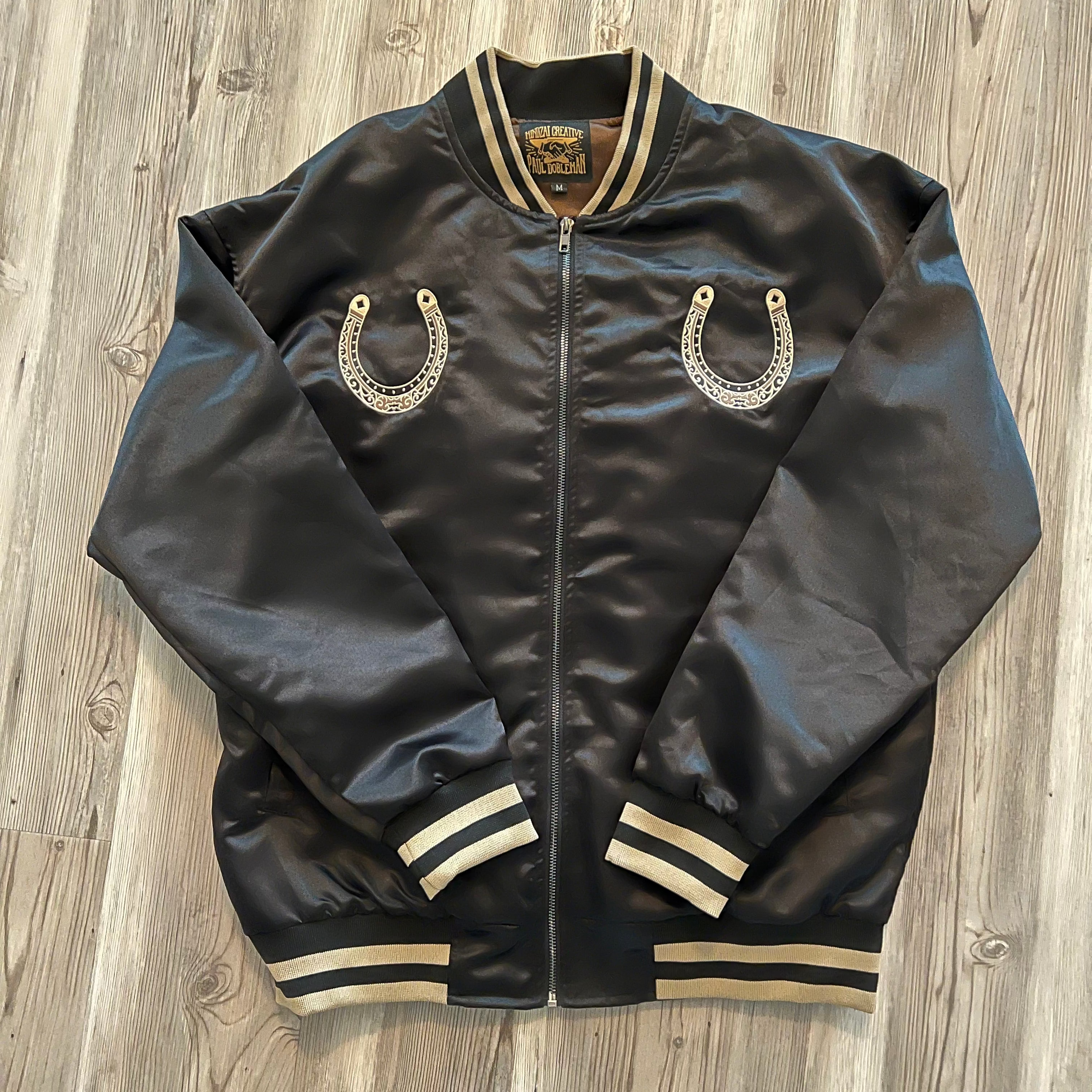 Embroidered horse detail on Year of the Horse bomber – gold and red stitching.