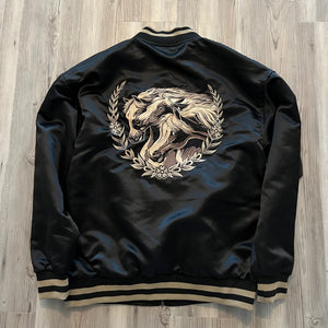 Close-up of satin fabric texture and embroidered horse detail on the bomber.